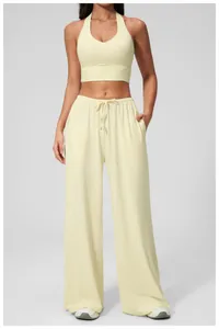 Detail of light yellow v-neck yoga top and matching high-waisted wide leg pants