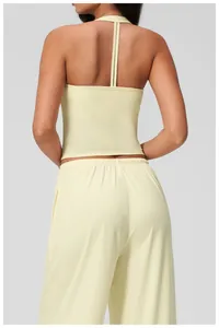 Detail of light yellow yoga crop top with halter neck and strappy open back design