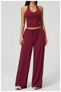 Slim fit burgundy yoga top and wide-leg trousers set shown on a model against white background