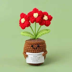 Handgefertigte Häkelblume im braunen Topf mit roten Blüten und weißer Grußkarte
