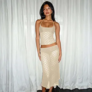 Détail de l'ensemble beige deux pièces avec haut dos nu en mesh à pois et jupe