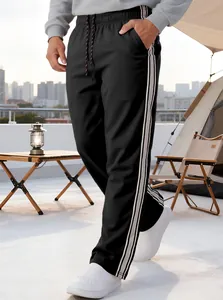 Detail view of men's athletic joggers featuring elastic drawstring waist and side stripes
