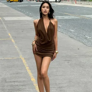 Detailed view of deep V-neck with metal decor on ruched backless brown dress