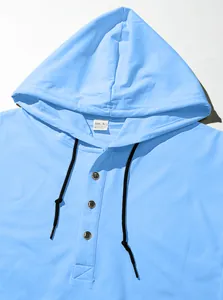 Detail of light blue hoodie neckline featuring a half-button placket and black drawstrings