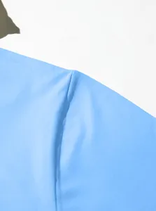 Macro shot of light blue cotton twill fabric showing fine texture and seam detail