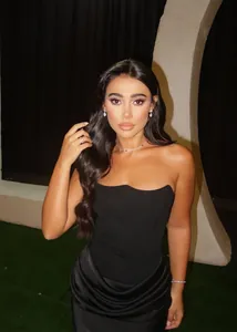 Détail d'une élégante robe de soirée corset noire avec jupe sirène en satin et bijoux fins