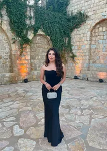 Détail de la robe sirène noire bustier avec plis à la taille et pochette argentée chic
