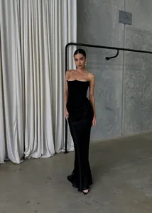 Détail de la texture satinée noire et de la coupe sirène sur cette robe de soirée chic