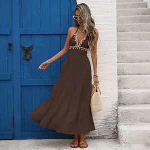 Détail de la robe marron avec col en V, bordures en coquillages et perles