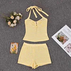 Flat lay of yellow striped knit two-piece set with halter top and metal ring detail