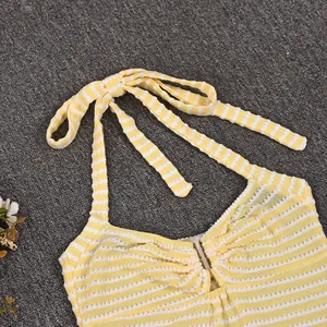 Detail of yellow striped halter neck top with knit texture and tie-up design