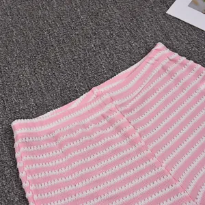 Detailed macro view of the elastic waistband on pink and white striped seersucker shorts