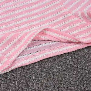 Detail of pink and white striped knit fabric showing wave texture and quality stitching