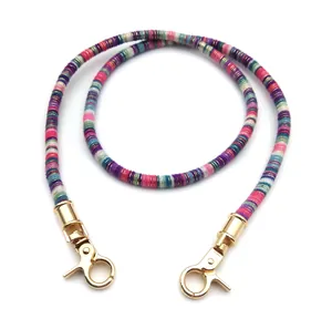Detail of colorful woven shoulder strap with dual golden metal lobster clasps