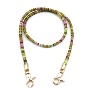 Detail of colorful woven bohemian bag strap with polished gold lobster clasps and patterns
