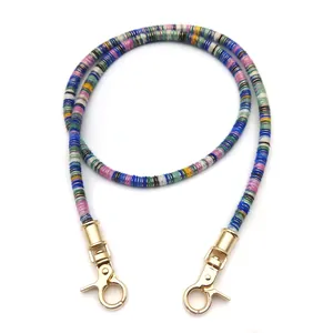 Detail of colorful disc bead strap with polished gold metal lobster clasps for bags