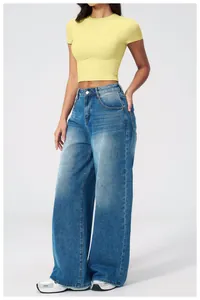 Detail shot of light blue high-waisted wide-leg jeans with natural faded denim texture