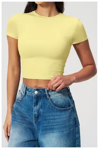 Close-up of a slim fit pale yellow crop top paired with vintage wash blue jeans