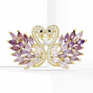 Close-up of golden swan brooch with purple crystals and sparkling micro-pave zircons