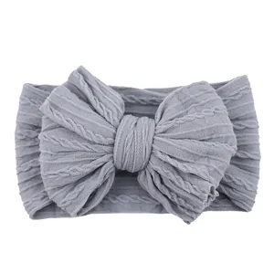 Elastic baby headband with large grey cable knit bow for newborns and infants
