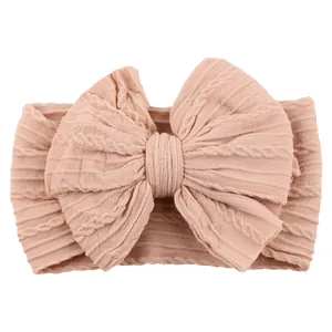 Soft matte nude pink jacquard baby headband with large bow and elastic knit texture