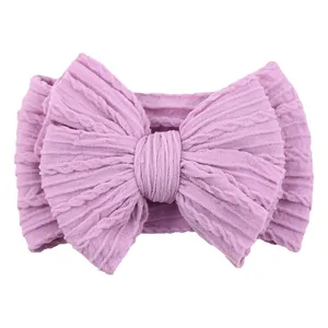 Elastic lilac knit baby headband with a large bow featuring a classic cable texture