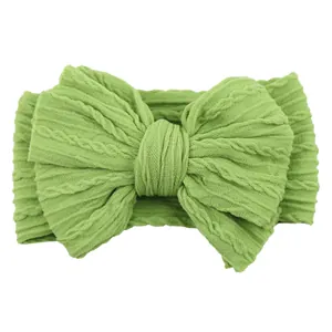 Grass green knitted baby headband featuring a large jacquard textured bow for infants