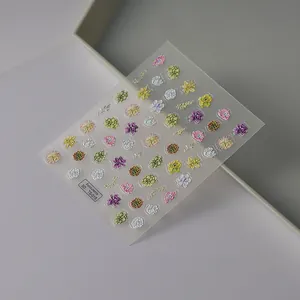 Gros plan détaillé des autocollants 5D gaufrés pour ongles avec fleurs et succulentes