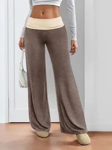 Detail of wide-leg trousers featuring a contrast turn-down beige waistband and soft fabric