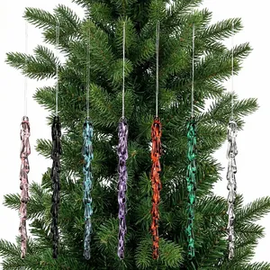 Detalle de siete adornos de carámbanos acrílicos de colores en una rama de árbol de Navidad