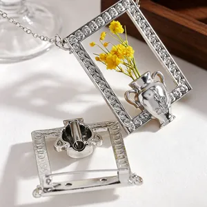 Detailed view of silver rectangular floral frame brooch with yellow dried flowers