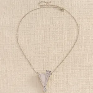 Macro shot of silver bouquet pendant necklace showing high polish and detailed lobster clasp