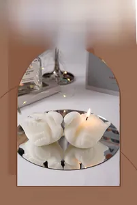 Macro shot of white swan scented candles with realistic feather textures on mirror