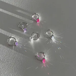 Macro shot of S925 silver hoop earrings with colorful zircons and starburst light effects