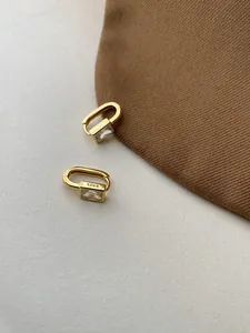 Detail shot of the S925 hallmark on a gold square hoop earring with zircon gemstone