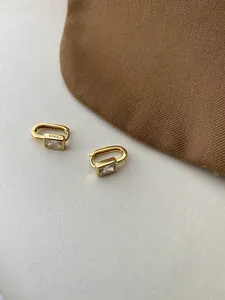 Macro view of gold S925 sterling silver hoop earrings with rectangular zircon stones