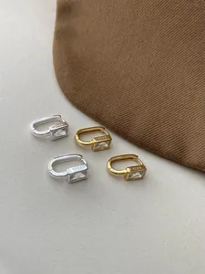 Detail of S925 sterling silver stamp on minimalist gold and silver zircon earrings