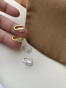 Macro view of S925 silver stamp and rectangular zircon setting on geometric earrings