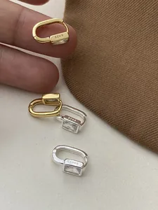 Macro shot of U-shaped S925 silver hoop earrings with rectangular cubic zirconia stones