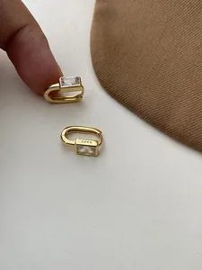 Close-up of gold S925 sterling silver rectangular hoop earrings with clear zircon stones