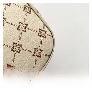 Close-up of litchi textured synthetic leather with vintage floral monogram pattern