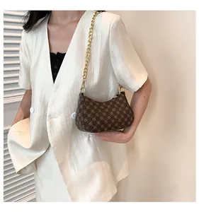 Detail of vintage brown crescent underarm bag with gold chain strap and chic prints