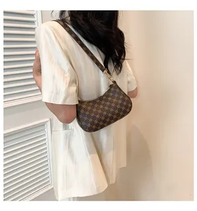 Brown vintage printed crescent bag shown on model with adjustable strap detail