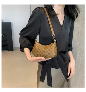 Close-up of brown geometric pattern shoulder bag with leather strap and metal buckle