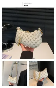 Macro detail of white baguette bag with brown geometric patterns and gold chain strap