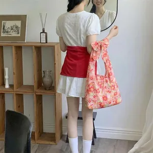 Pink floral tote bag featuring a large decorative bow and soft fabric handles