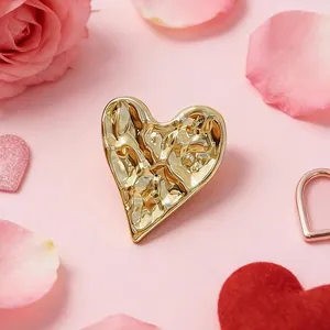Detail of 3D heart brooch with hammered gold texture and romantic rose background