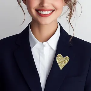 Golden heart brooch with hammered texture on a navy blue professional suit lapel