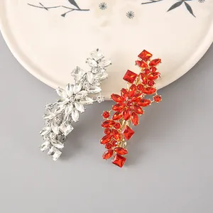 Détail de barrettes florales avec cristaux blancs argentés et diamants rouges dorés