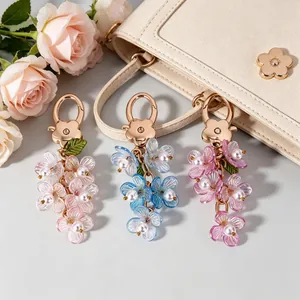 Luminous floral keychains with pearls and gold clasps on a stylish handbag